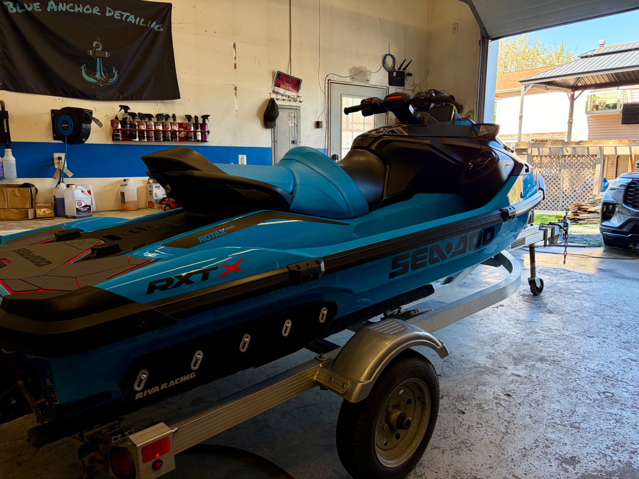 Turquoise Sea-Doo personal watercraft on a trailer inside the Blue Anchor Detailing shop.