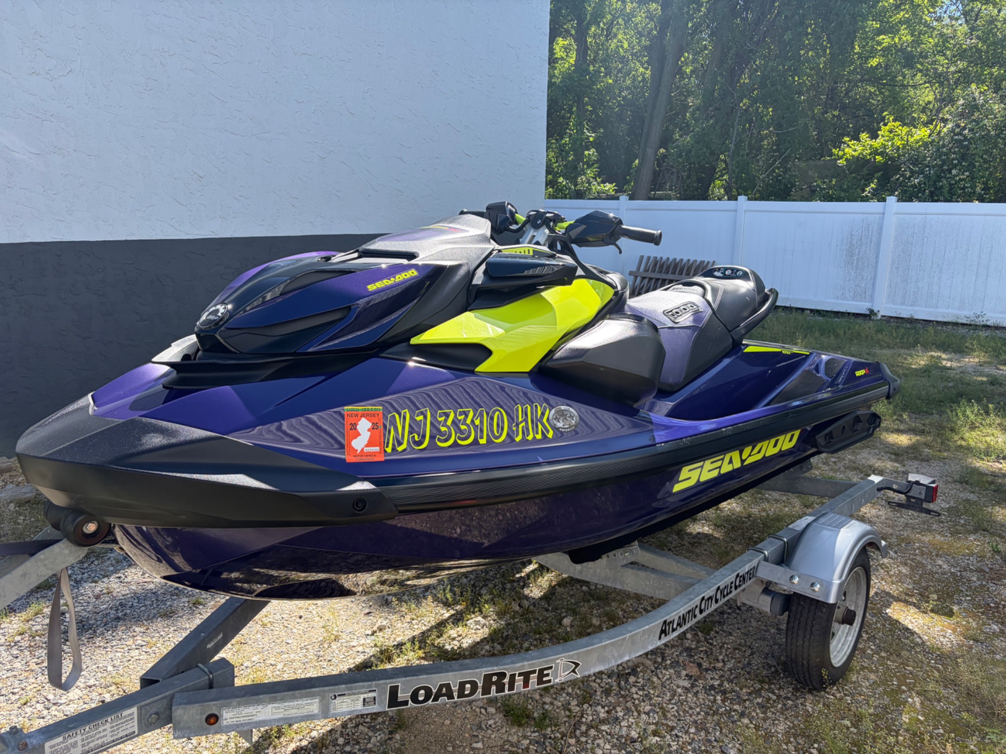 Purple and lime Sea-Doo personal watercraft on a trailer outdoors after detailing.